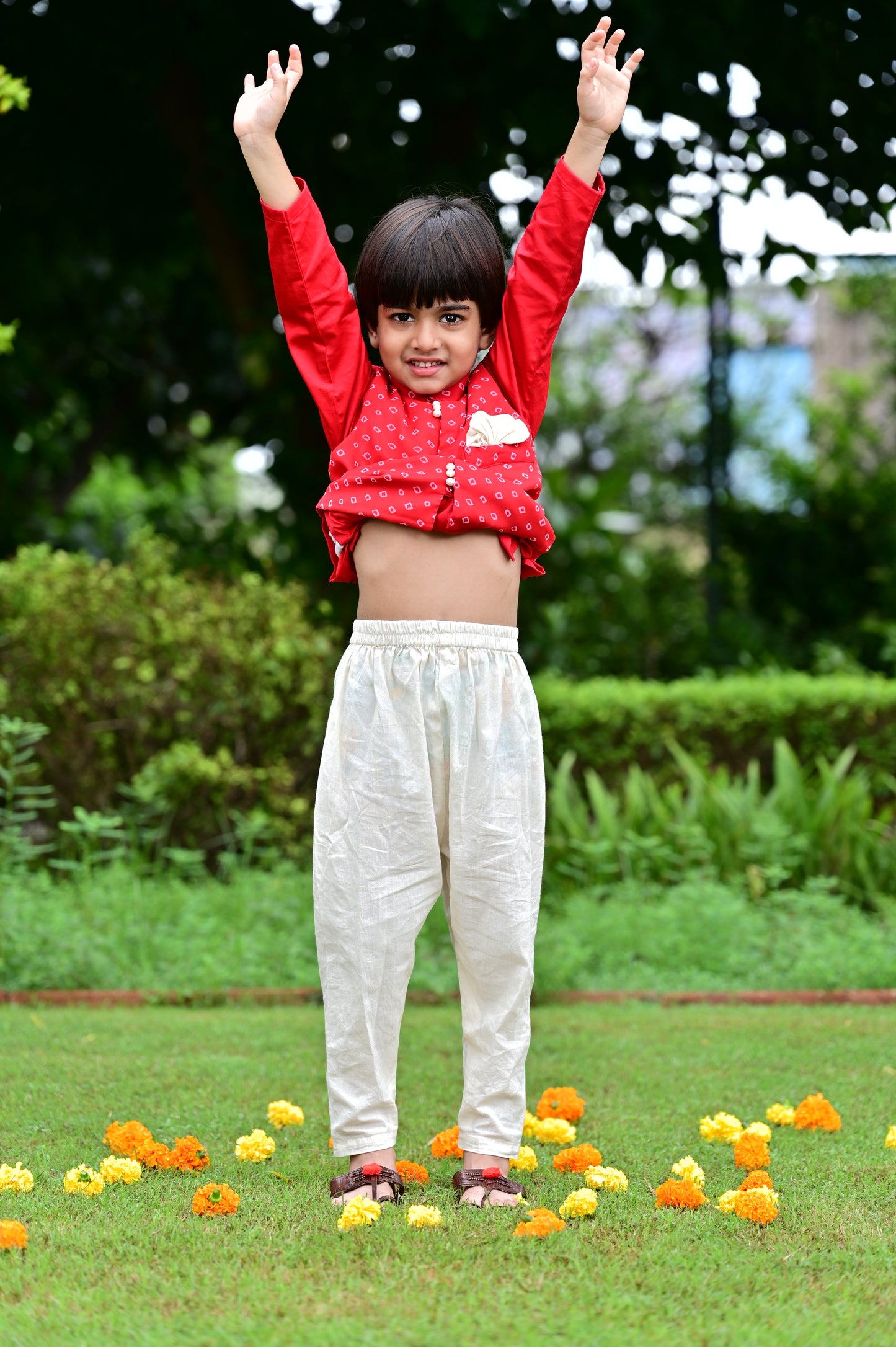 Boys red cotton kurta with off white cotton pajama along with a bandhani print jacket