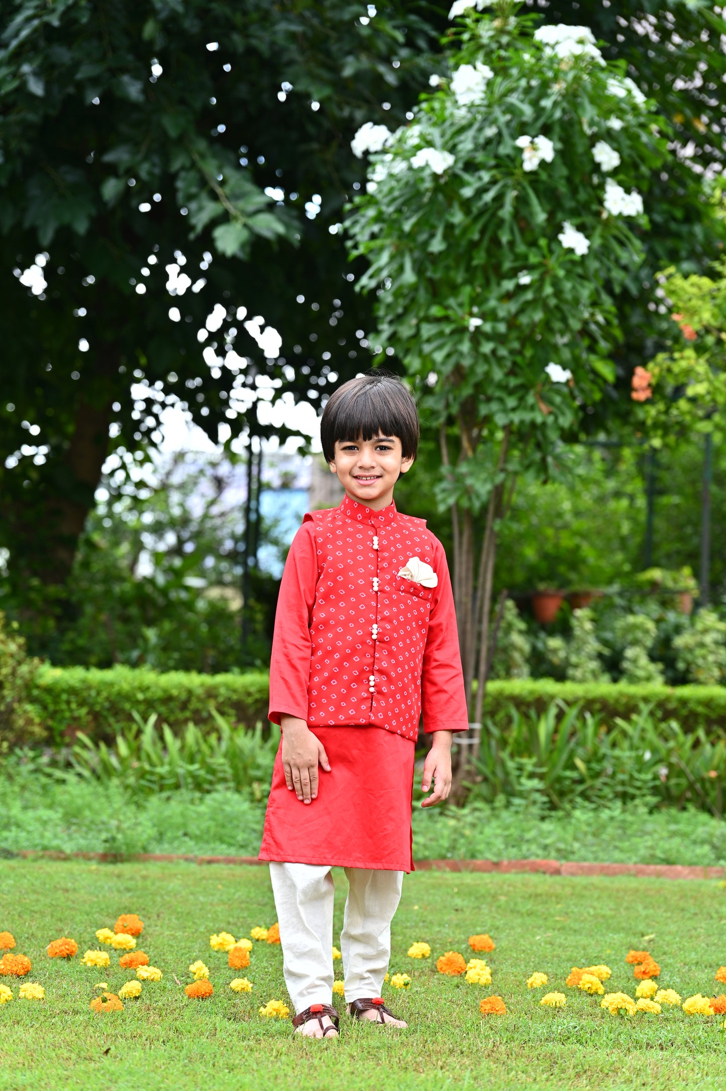 Boys red cotton kurta with off white cotton pajama along with a bandhani print jacket