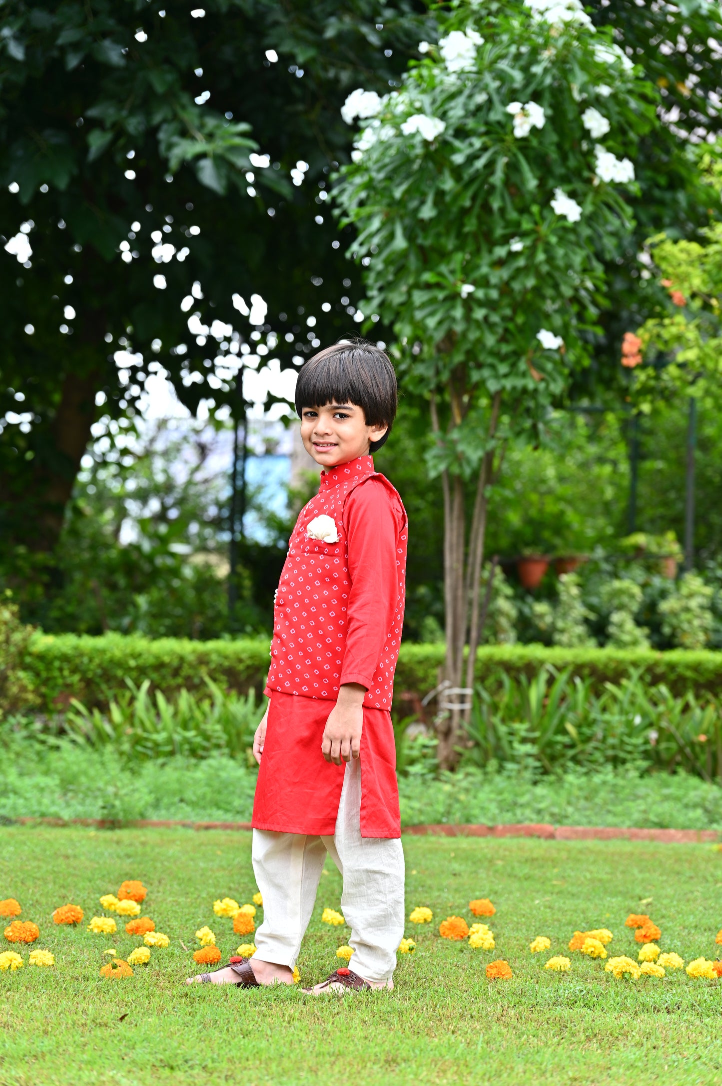 Boys red cotton kurta with off white cotton pajama along with a bandhani print jacket