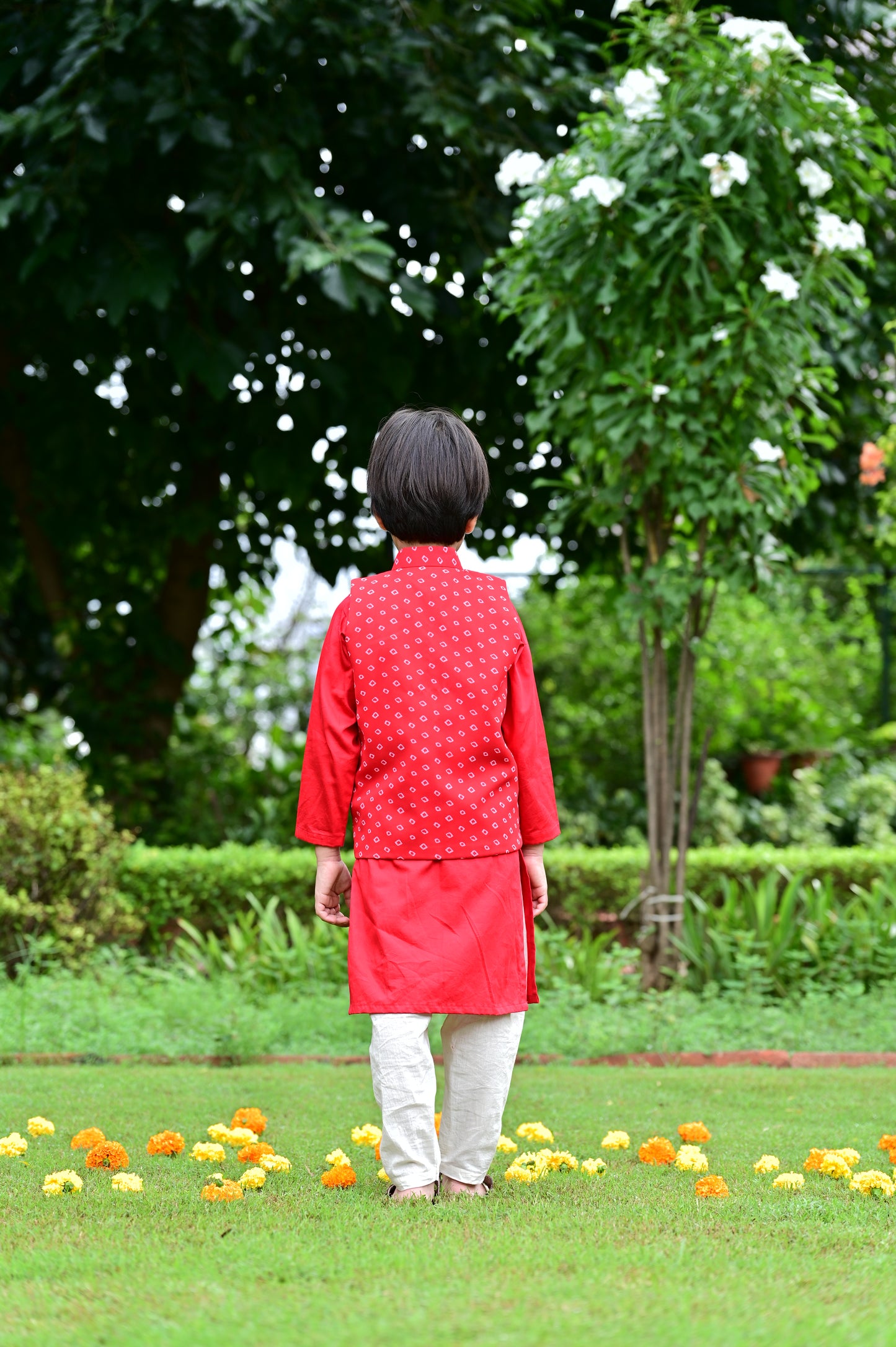 Boys red cotton kurta with off white cotton pajama along with a bandhani print jacket